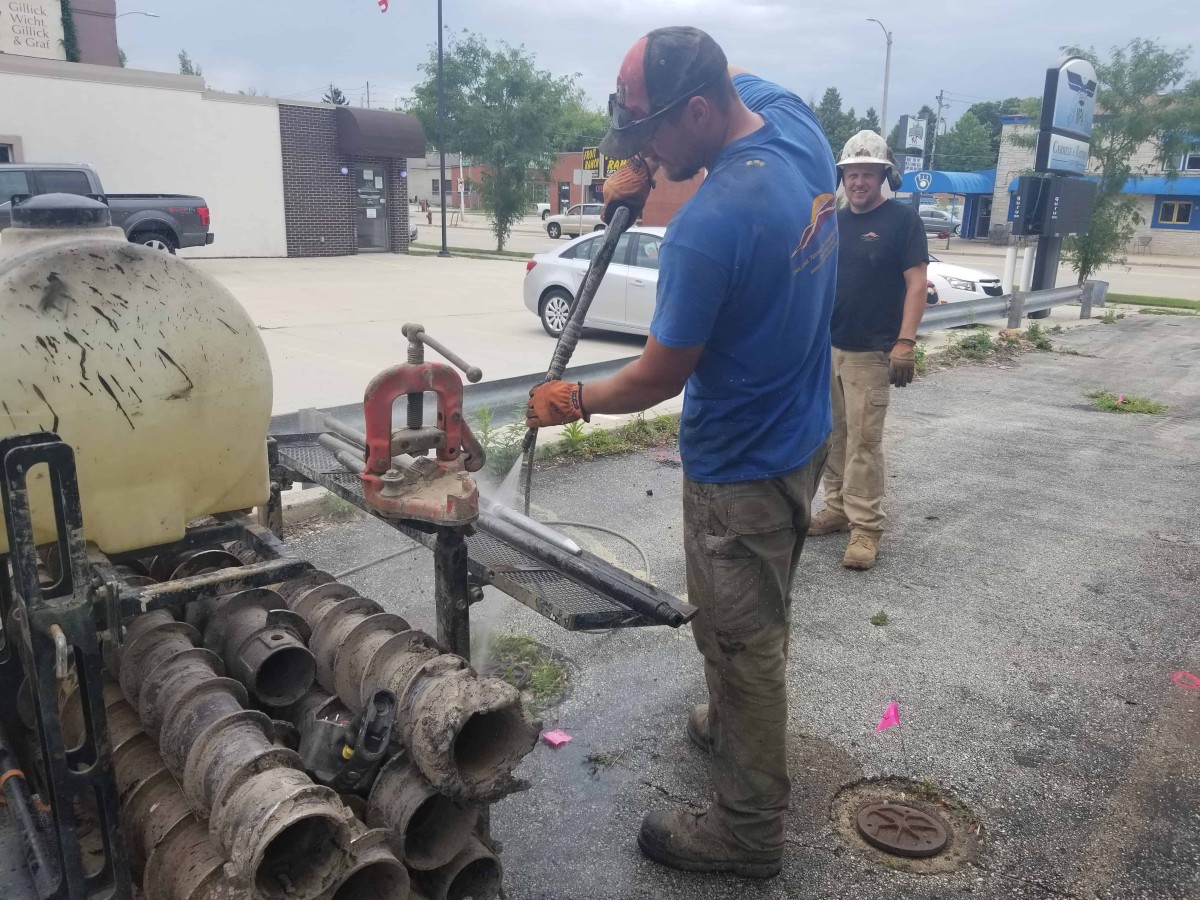 Remediation crew members clean injection rods before performing a bioremediation injection.